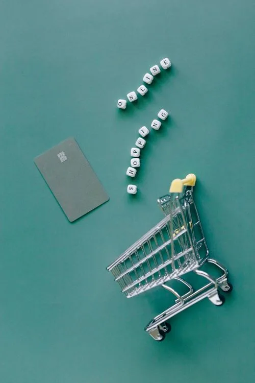 Online shopping cart and card on a green backdrop